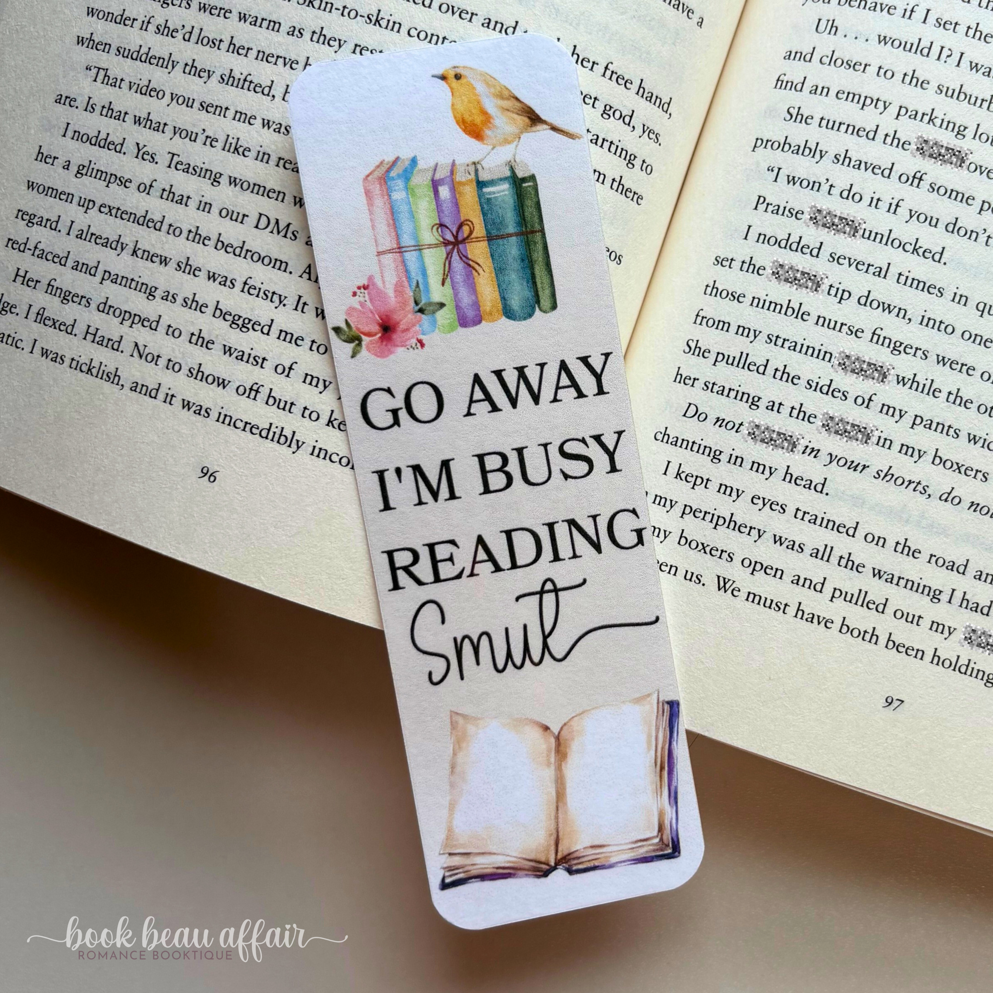 Bookmark with 'Go Away I'm Busy Reading Smut' text on an open book, brand 'book beau affair' visible