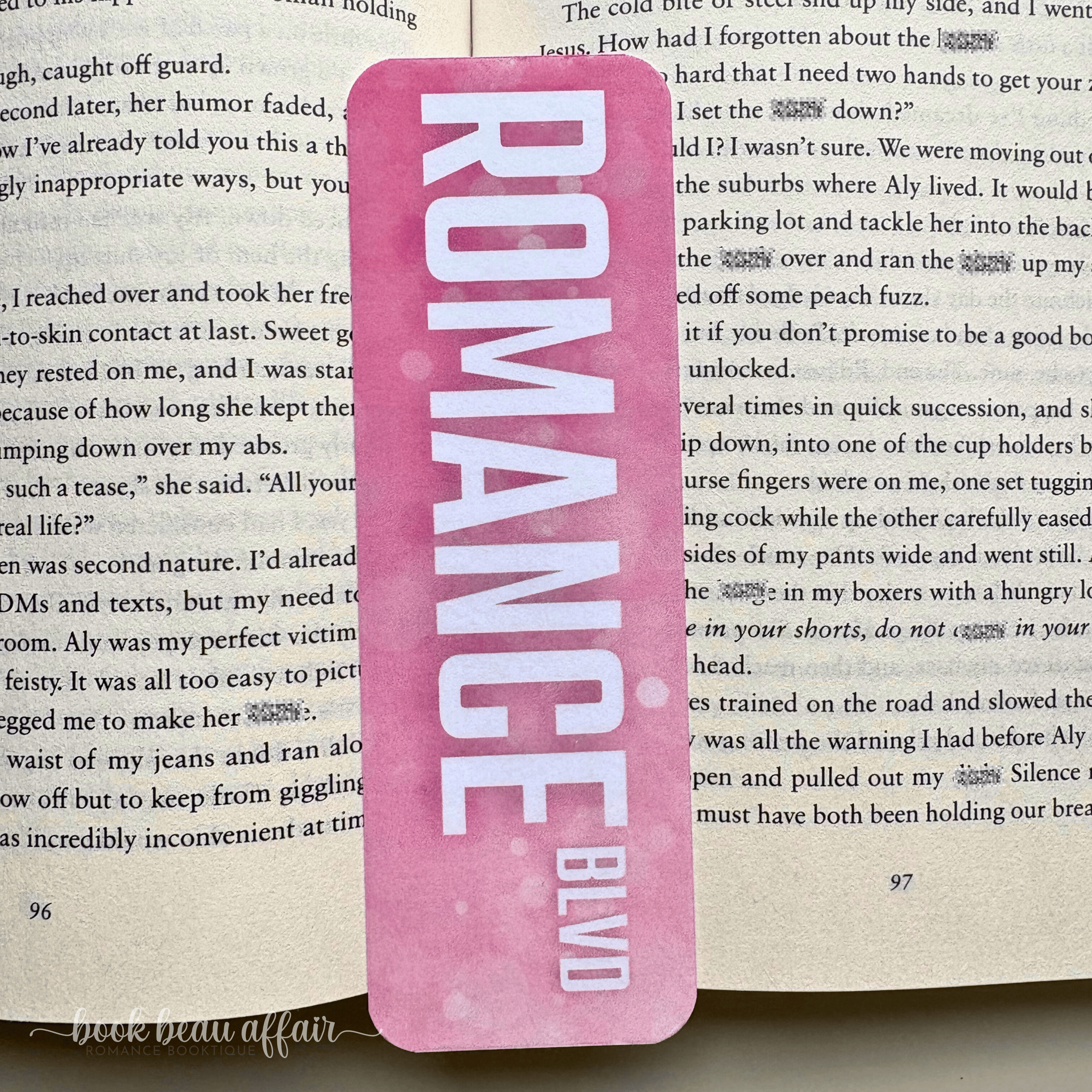 Pink bookmark with 'ROMANCE BLVD' text on a book