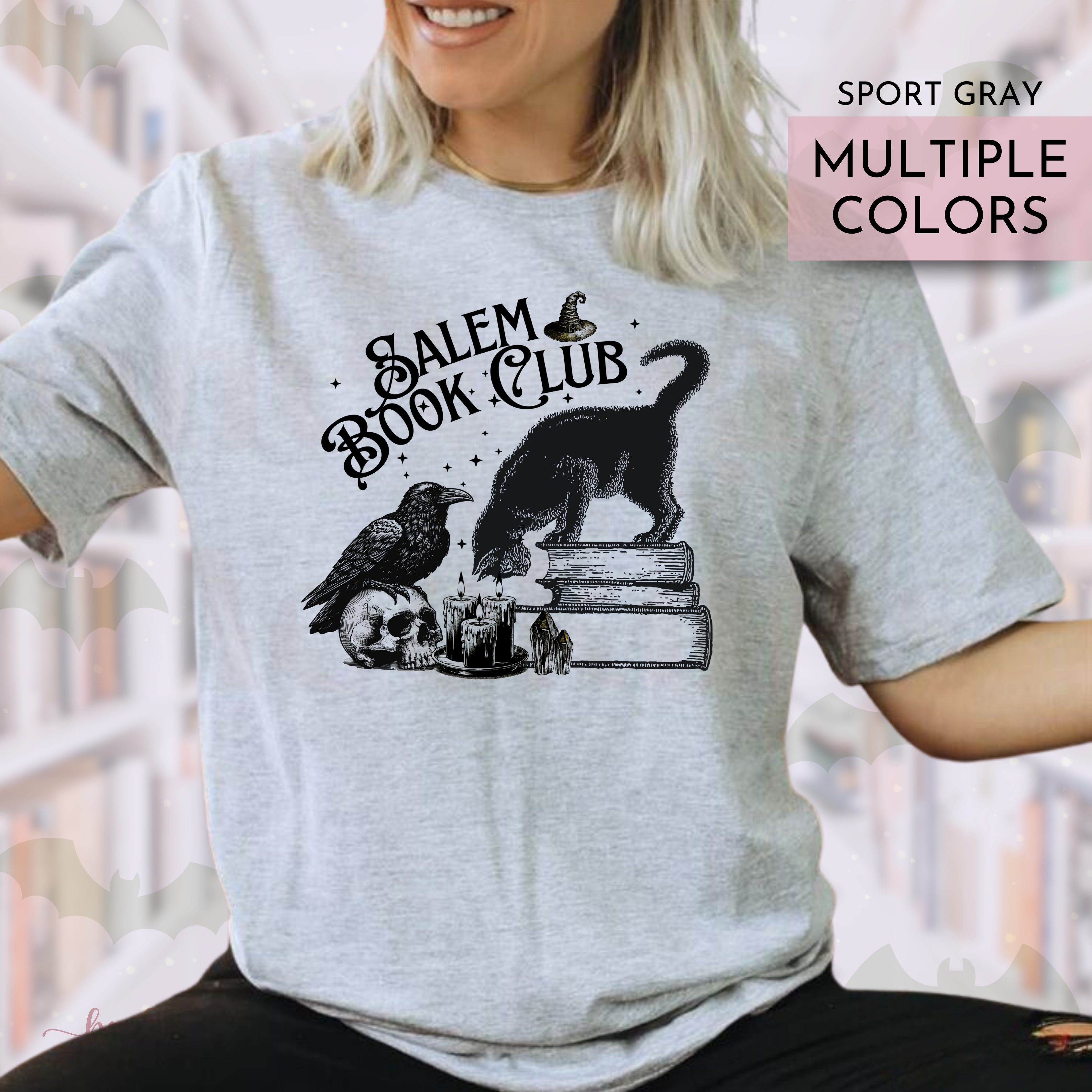 Person wearing a gray t-shirt with 'Salem Book Club' design, featuring a black cat, bird, and skull.
