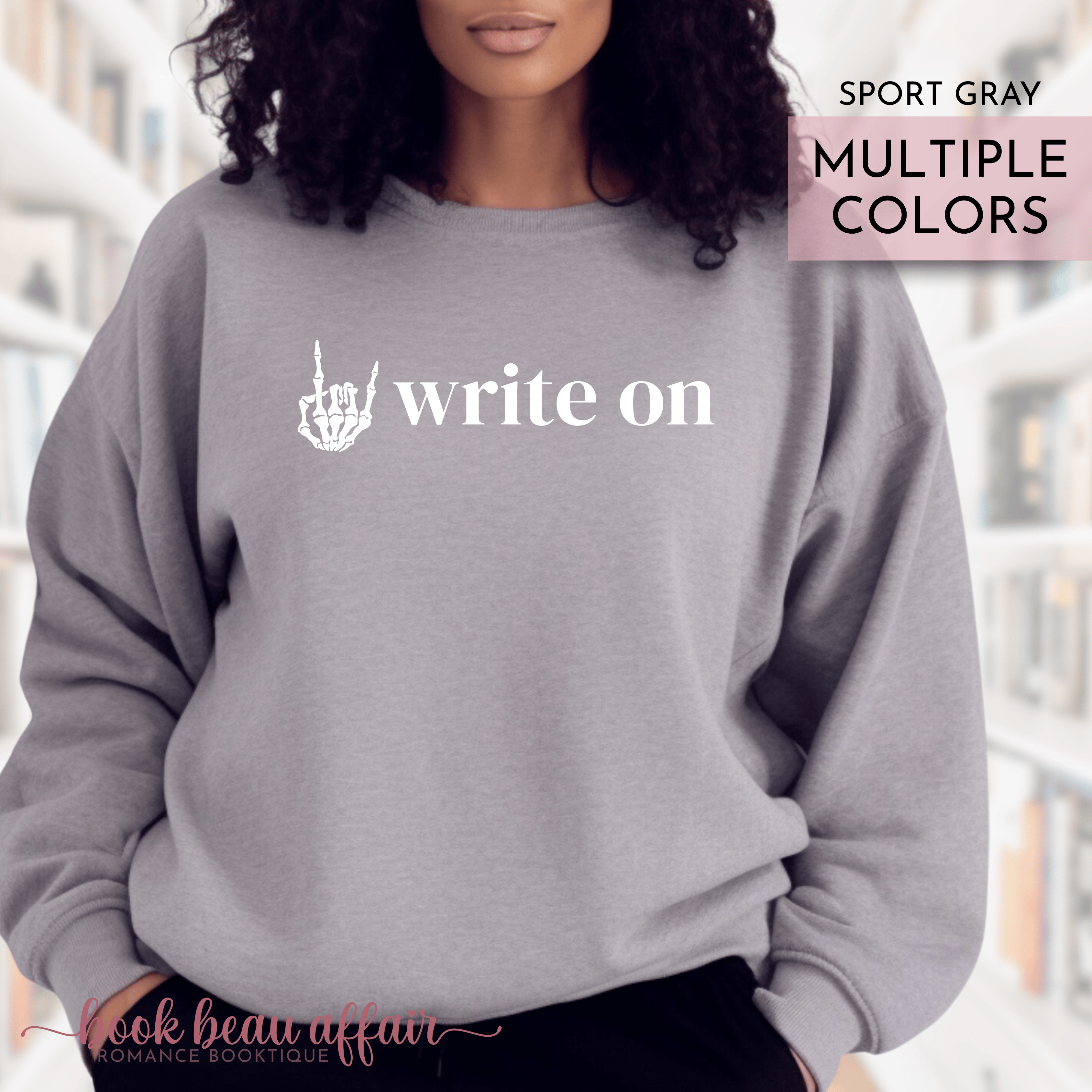 Gray sweatshirt with 'write on' text and rock on hand gesture design, worn by a person.
