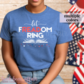 Person wearing a blue t-shirt with 'let FREEDOM RING' text in front of American flags.