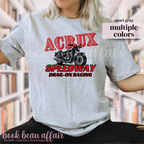 Person wearing a gray t-shirt with a motorcycle graphic and text, that says Acrux Speedway. Drag-on racing