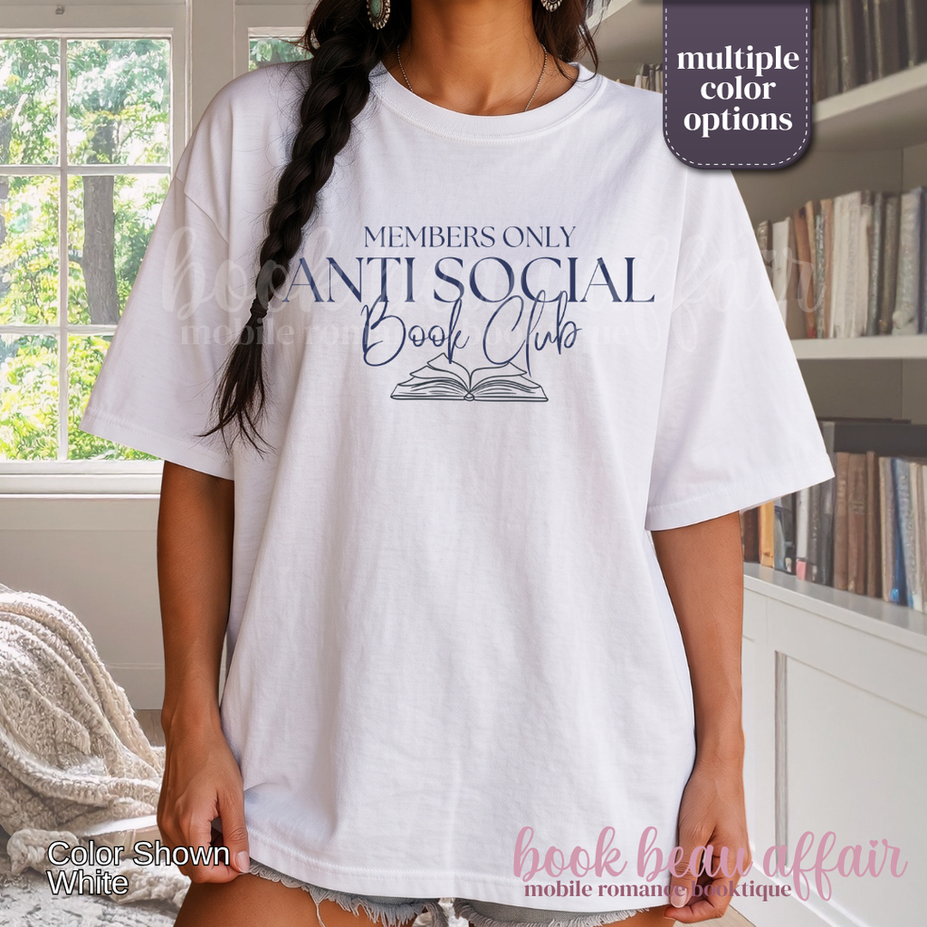 A woman wearing a white graphic t-shirt with navy blue text that reads 'MEMBERS ONLY ANTI SOCIAL Book Club' and an illustration of an open book. 