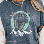 Gray t-shirt with teal headphones graphic and text 'I can't hear you, I'm listening to my Audiobook' on a white background.