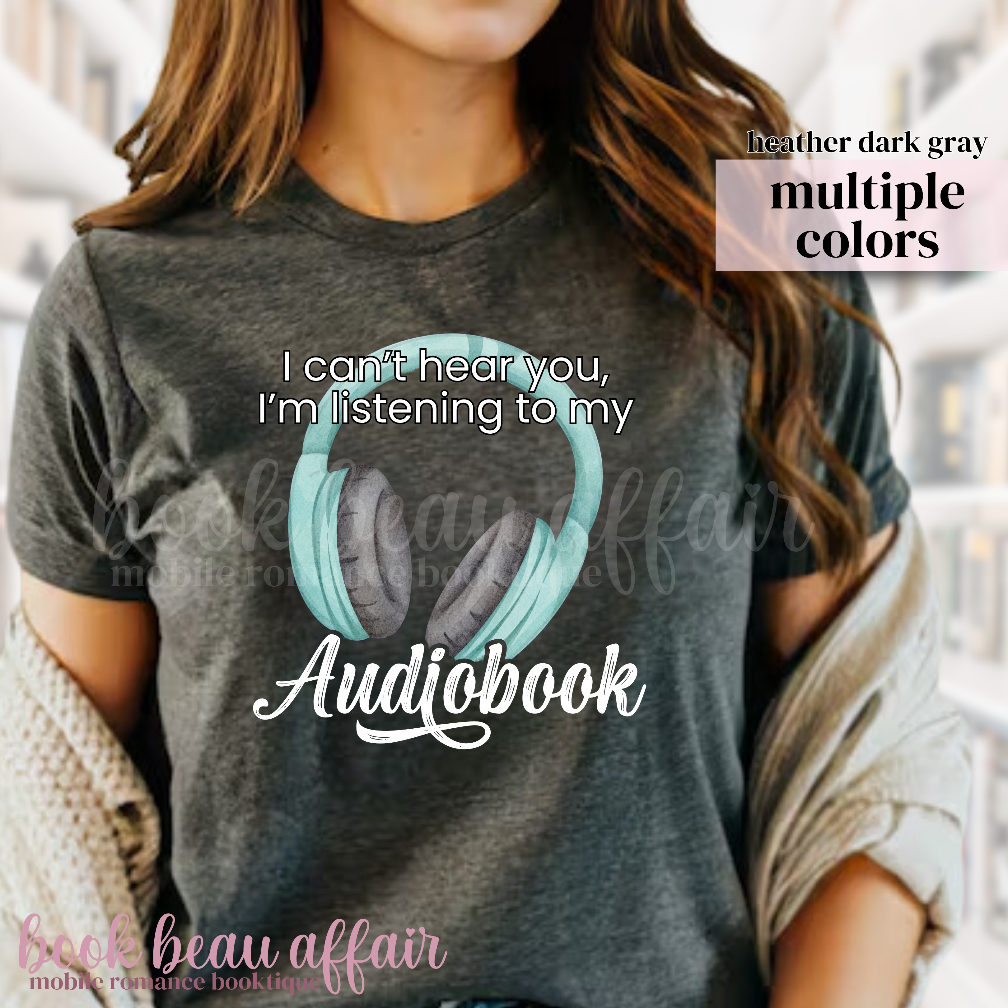 Person wearing a t-shirt with 'I can't hear you, I'm listening to my audiobook' text and headphones graphic.