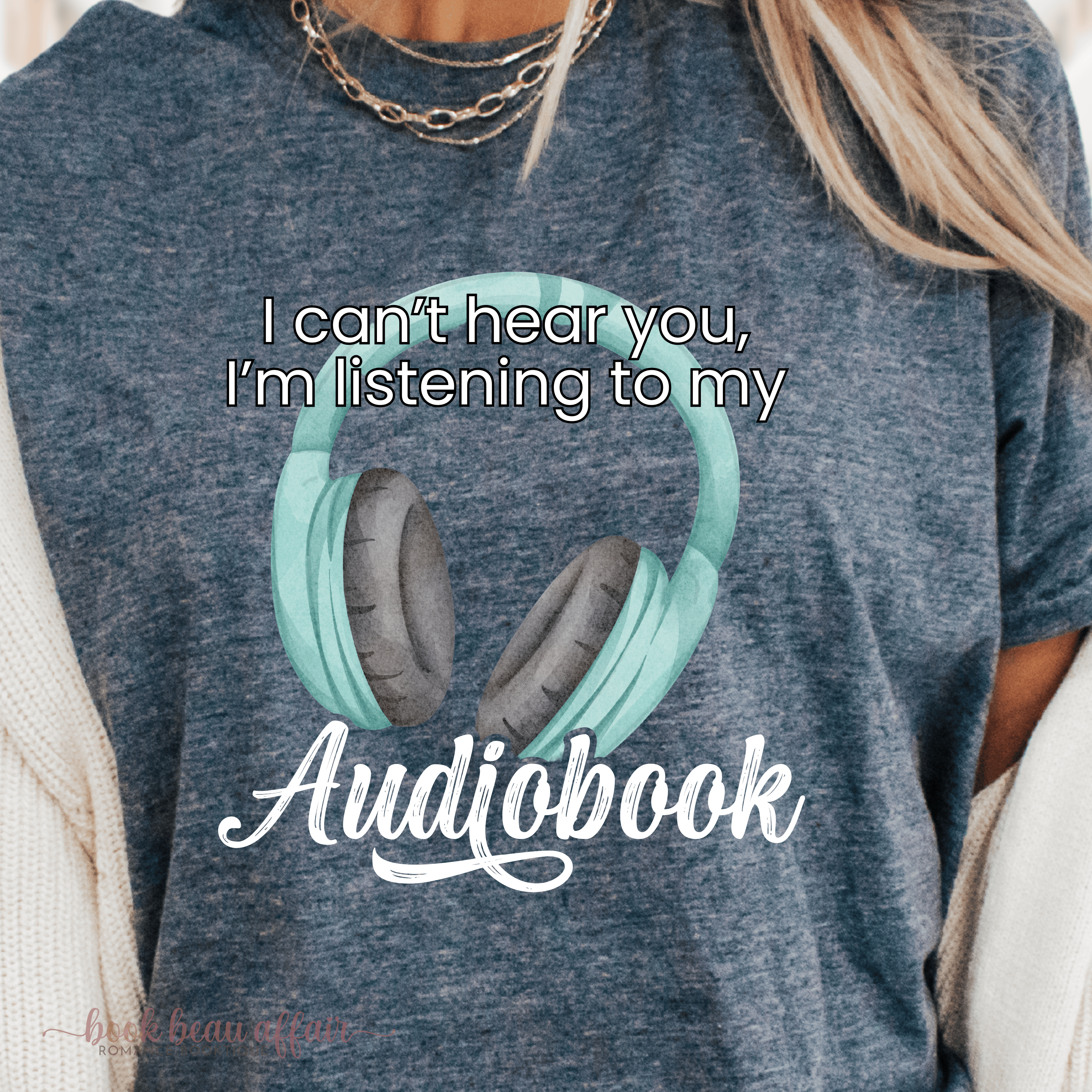 Gray t-shirt with teal headphones graphic and text 'I can't hear you, I'm listening to my Audiobook' on a person wearing it.