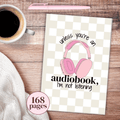 Notebook with pink headphones illustration and text on a checkered background, next to a cup of coffee and pen with text that says unless you're an audiobook, I'm not listening