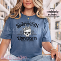 Person wearing a blue t-shirt with text and skull design in a library setting. The text on the shirt says I vow. You Vow. We Vow. Barrington University. House of Lords.