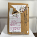 Blind Date with a Book. Mystery Book Wrapped in brown craft paper with a pen, stickers, bookmarks and other goodies