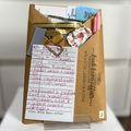 Blind Date with a Book. Mystery Book Wrapped in brown craft paper with a pen, stickers, bookmarks and other goodies