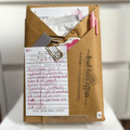 Blind Date with a Book. Mystery Book Wrapped in brown craft paper with a pen, stickers, bookmarks and other goodies