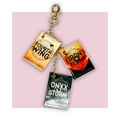 Keychain with book charm designs on a pink background