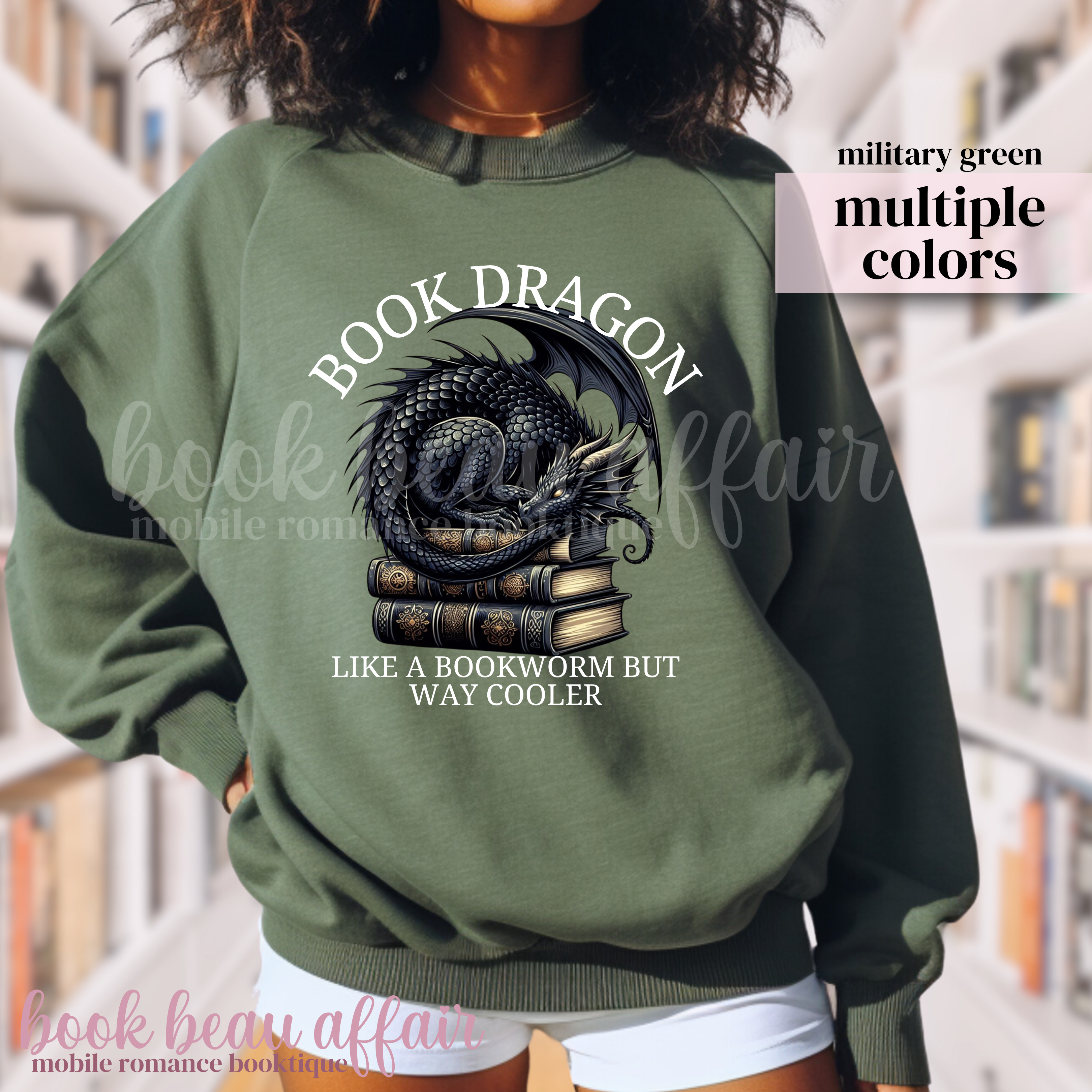 military green sweatshirt with a dragon laying on a stack of books and text that says book dragon, like a bookworm but way cooler