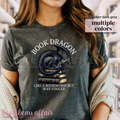 Dark Gray t-shirt with a dragon laying on a stack of books and text that says book dragon, like a bookworm but way cooler