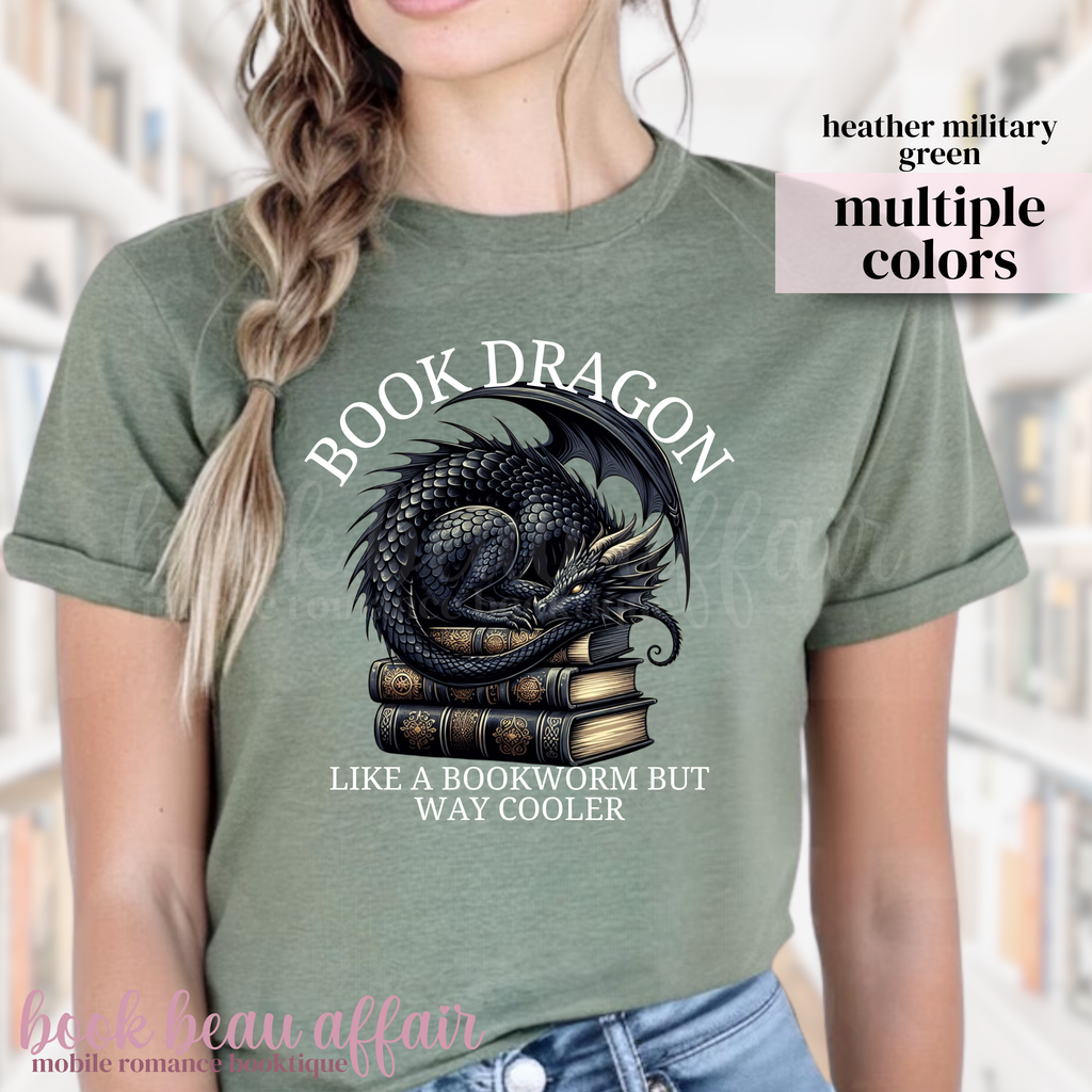 military green t-shirt with a dragon laying on a stack of books and text that says book dragon, like a bookworm but way cooler