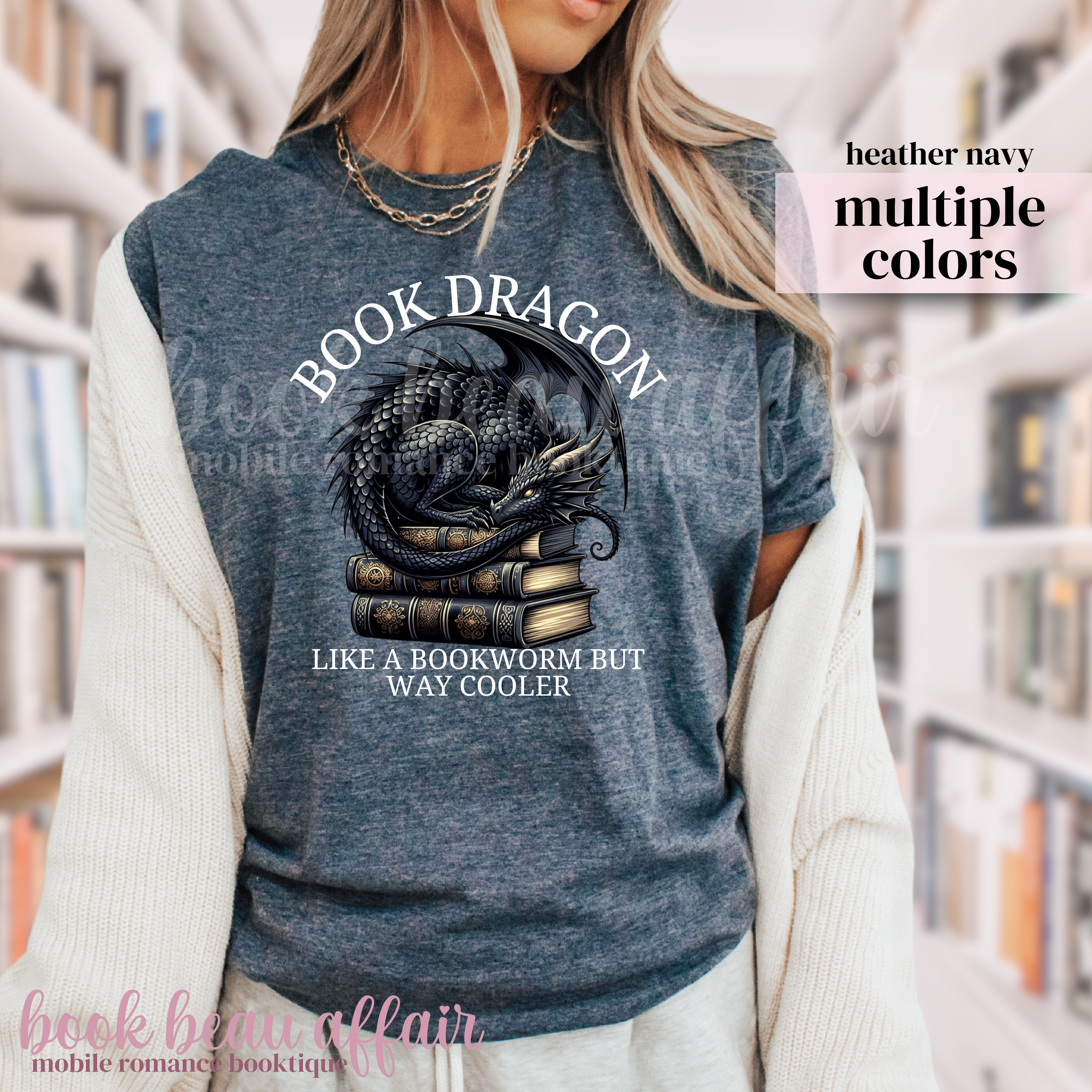 heather navy blue t-shirt with a dragon laying on a stack of books and text that says book dragon, like a bookworm but way cooler