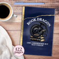 Notebook with dragon design titled 'Book Dragon' on a wooden surface with coffee and sweater.