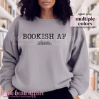 Person wearing a gray sweatshirt with 'BOOKISH AF' text in a library setting