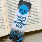 Bookmark with skull design and text on an open book. the text says I don't need another kink