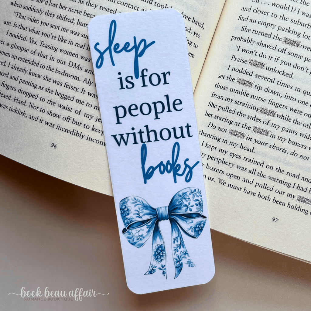 Bookmark with 'sleep is for people without books' text on an open book