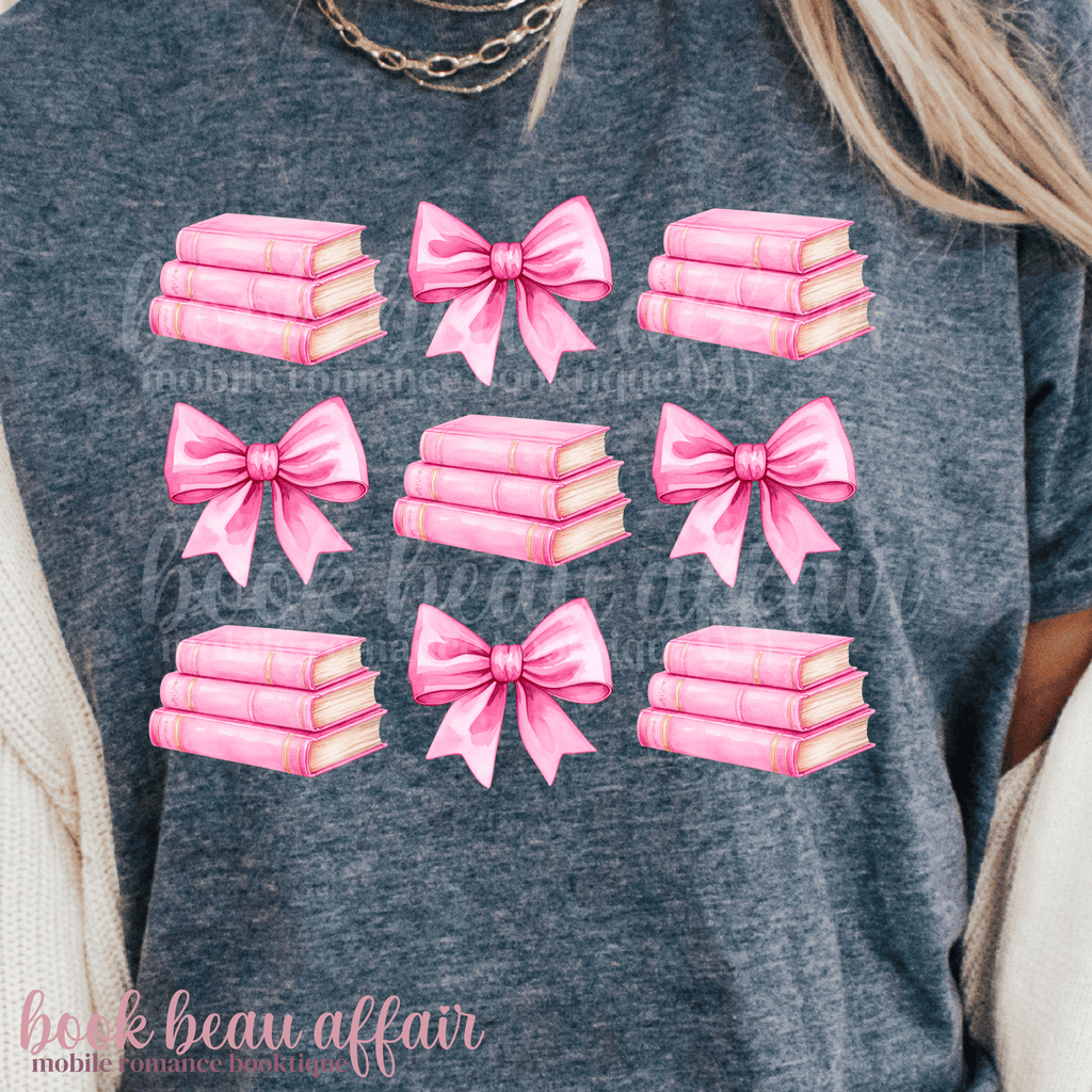navy blue t-shirt with pink bows and pink stacks of books.