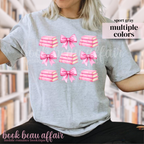 gray t-shirt with pink bows and pink stacks of books.