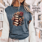 Navy t-shirt with a design of books and flowers on a person wearing it.