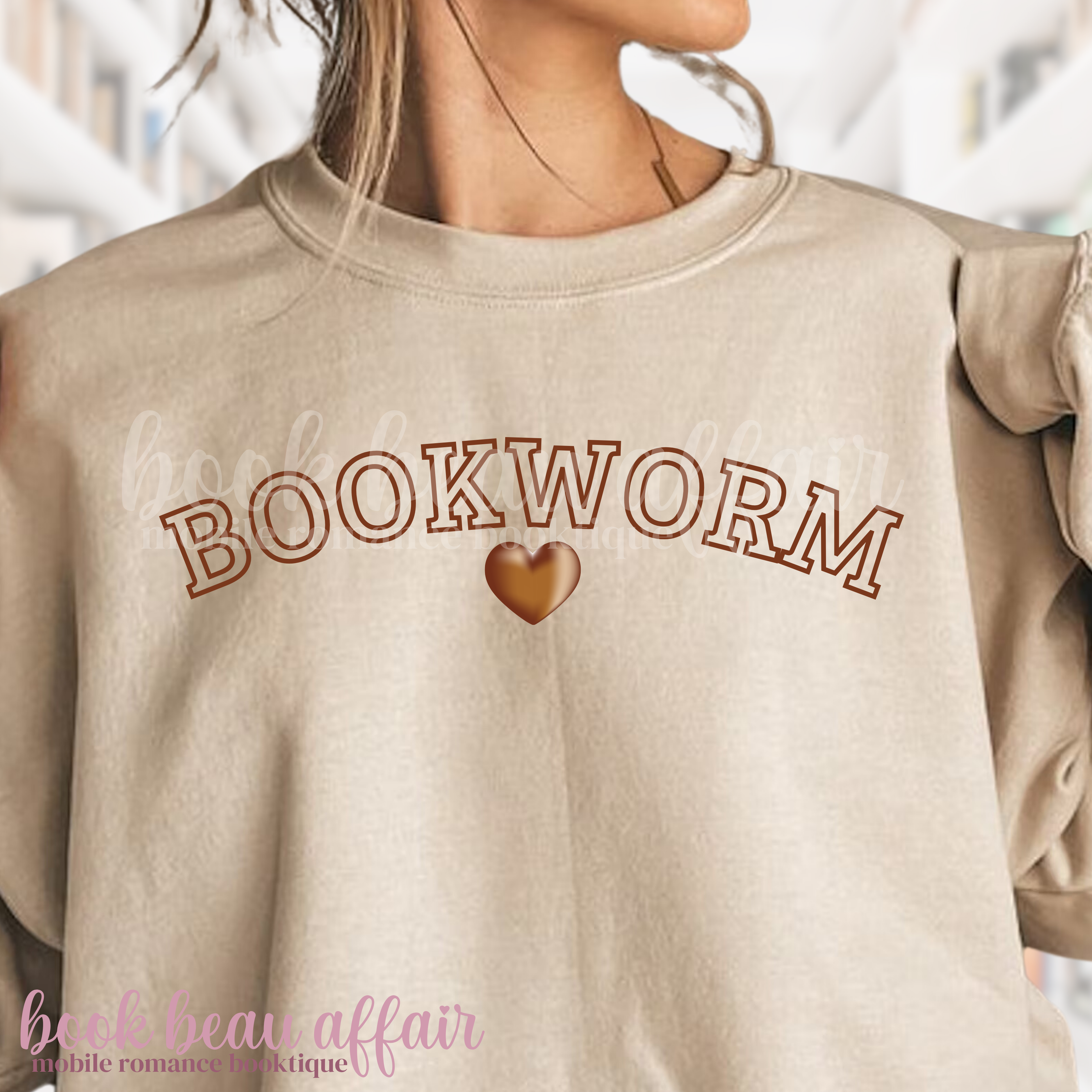 Beige sweatshirt with 'BOOKWORM' text and heart graphic, worn by a person.