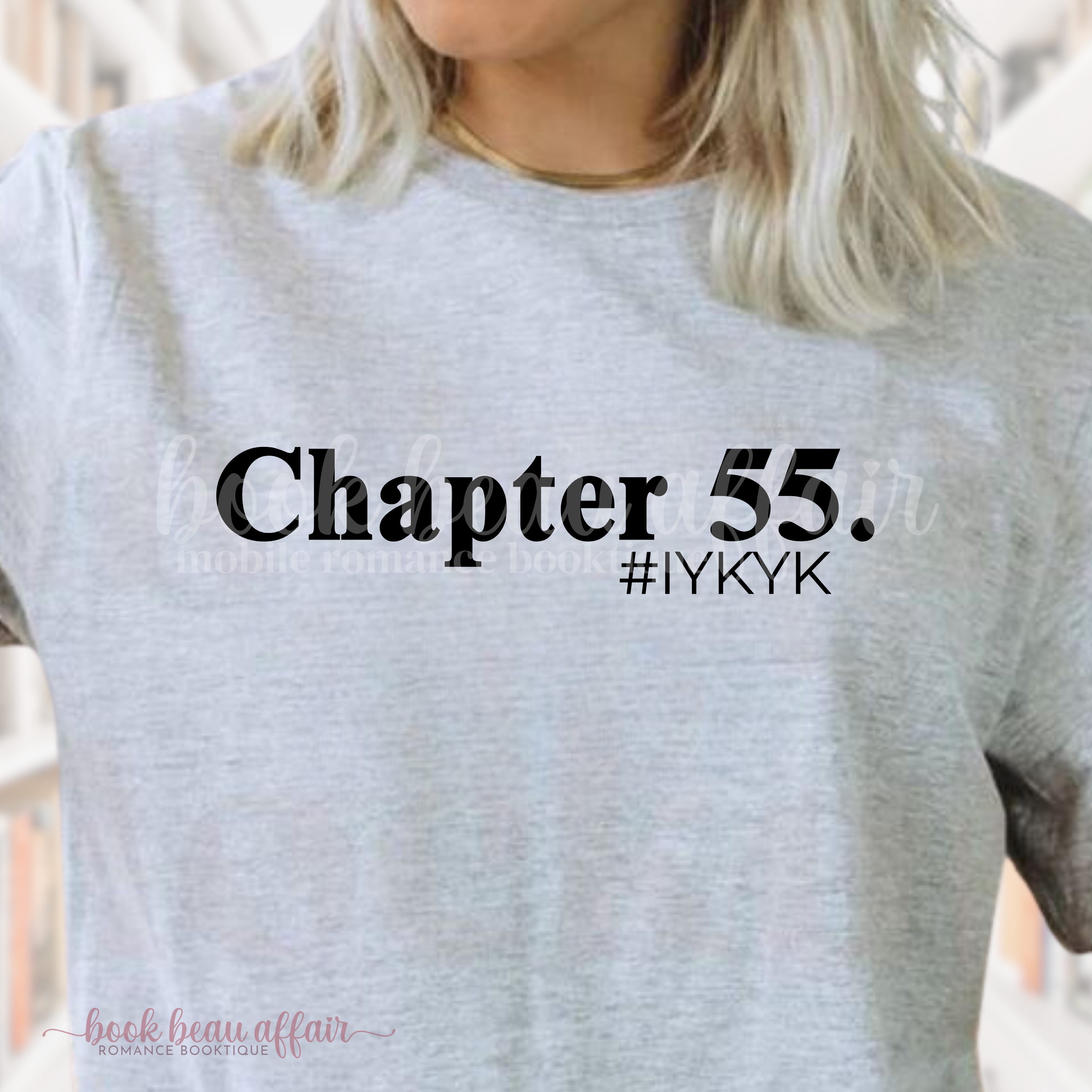 Person wearing a gray t-shirt with 'Chapter 55.' and '#IYKYK' text.