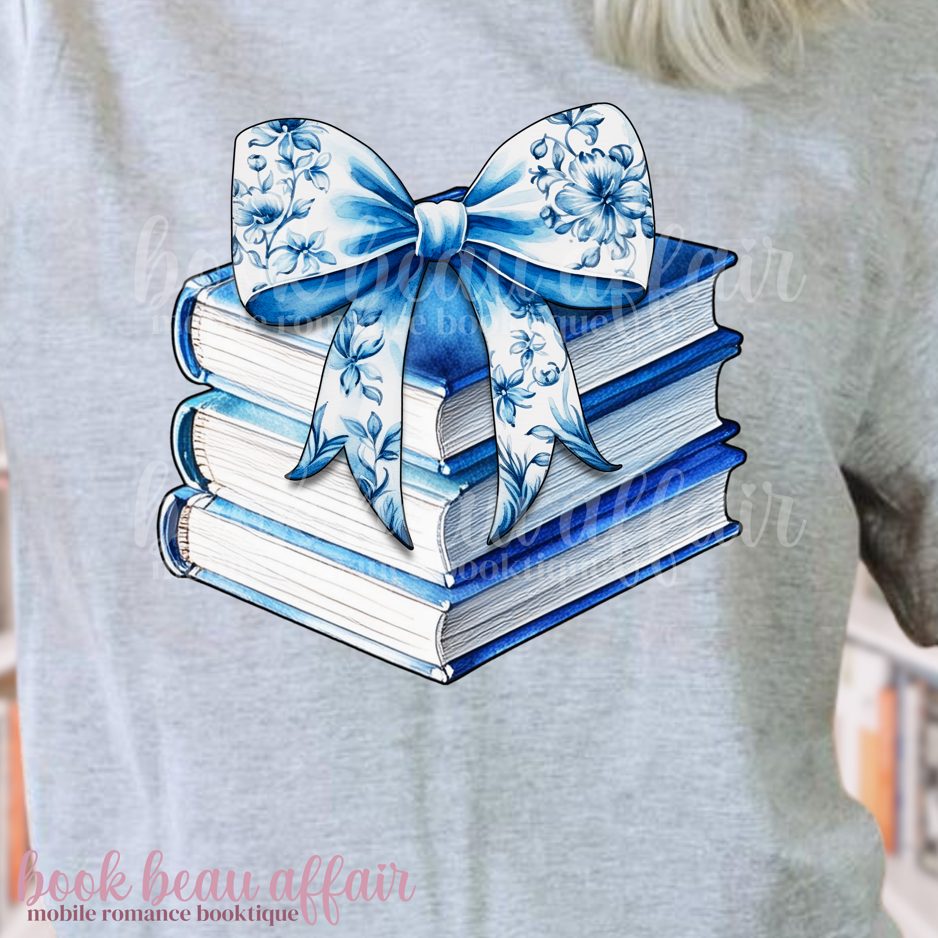 Stack of books with a blue floral bow on a gray t-shirt