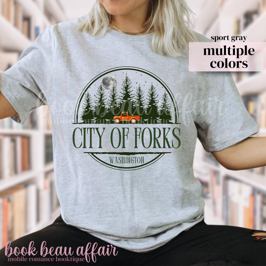 Person wearing a gray t-shirt with 'City of Forks, Washington' graphic design.