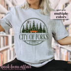 Person wearing a gray t-shirt with 'City of Forks, Washington' graphic design.