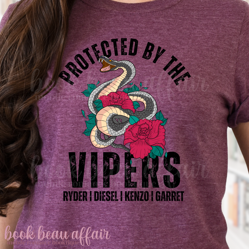 Maroon t-shirt with snake and rose design and text 'Protected by the Vipers' on a blurred background.