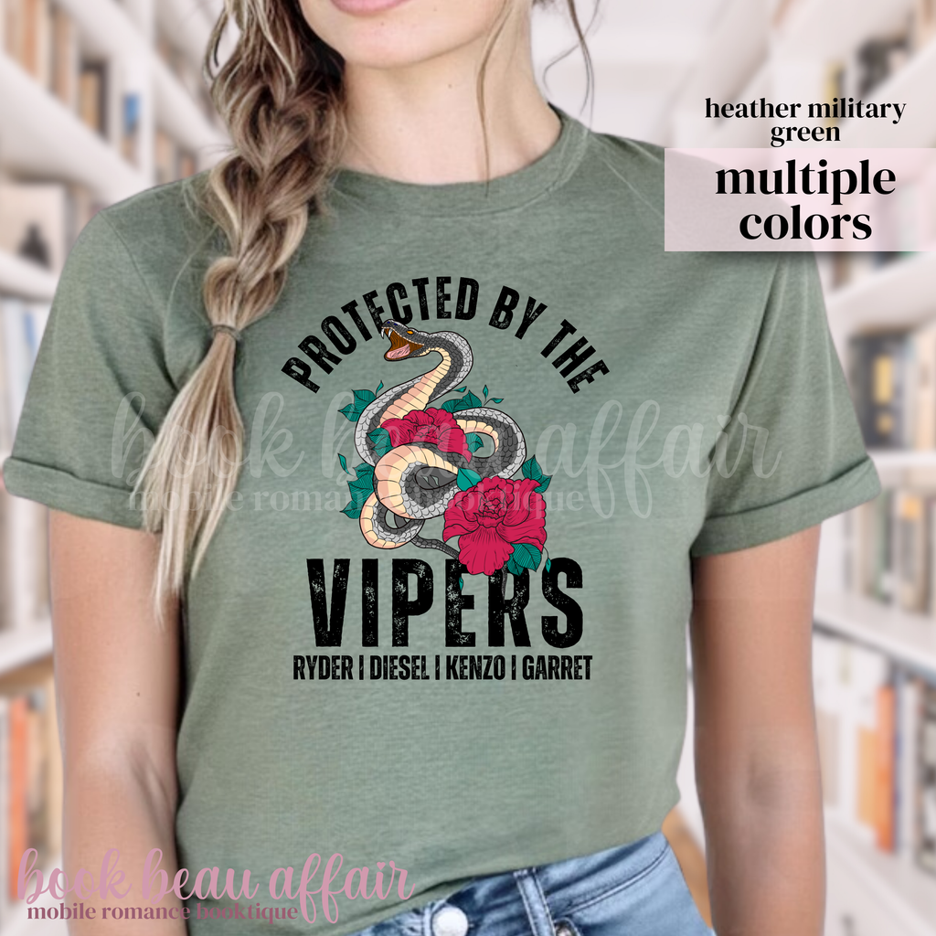 Person wearing a green t-shirt with 'Protected by the Vipers' design in a library setting