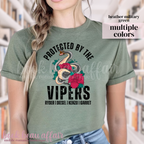 Person wearing a green t-shirt with 'Protected by the Vipers' design in a library setting