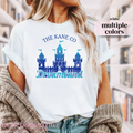White t-shirt with a blue castle and text that says "The Kane Co Dreamland"