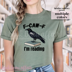Green t-shirt with a crow on a book graphic and text 'F-CAW-F I'm reading' 