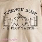 Beige t-shirt with 'Pumpkin Bliss & Plot Twists' text and pumpkin graphic on a beige background.