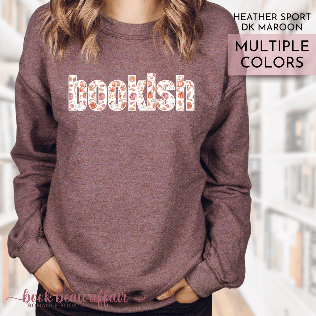 Heather dark maroon sweatshirt with 'bookish' text in multiple colors, worn by a person.