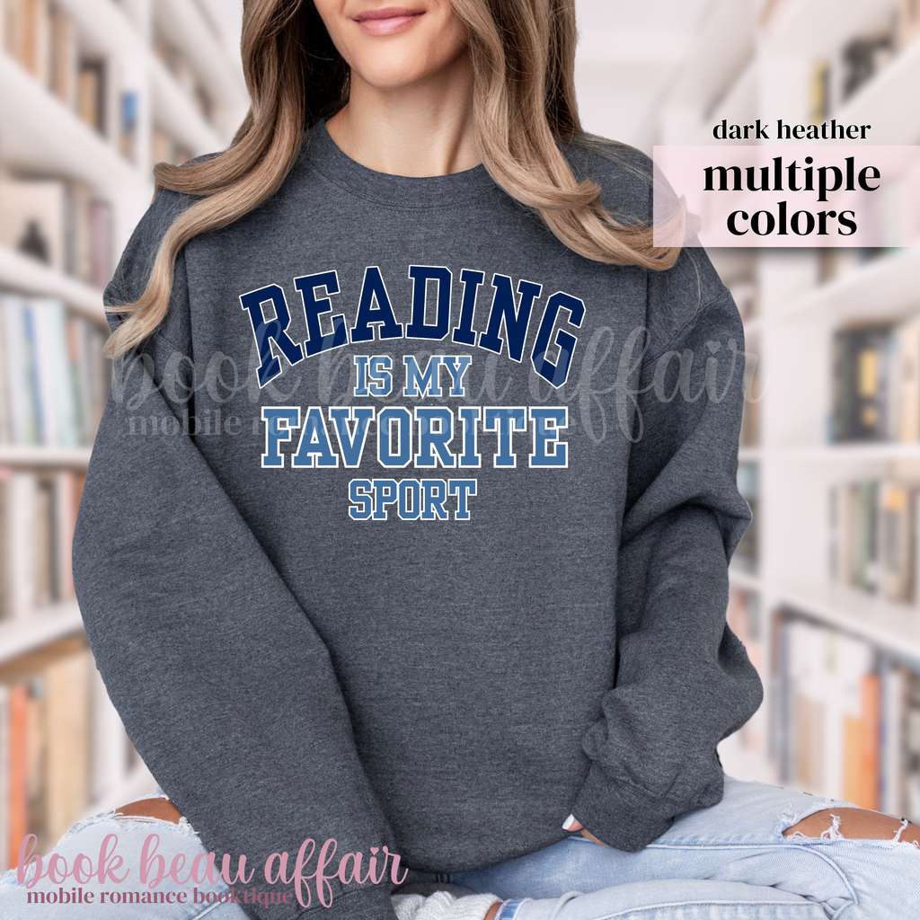 Person wearing a dark Heather sweatshirt with 'Reading is my favorite sport' text in a library setting.