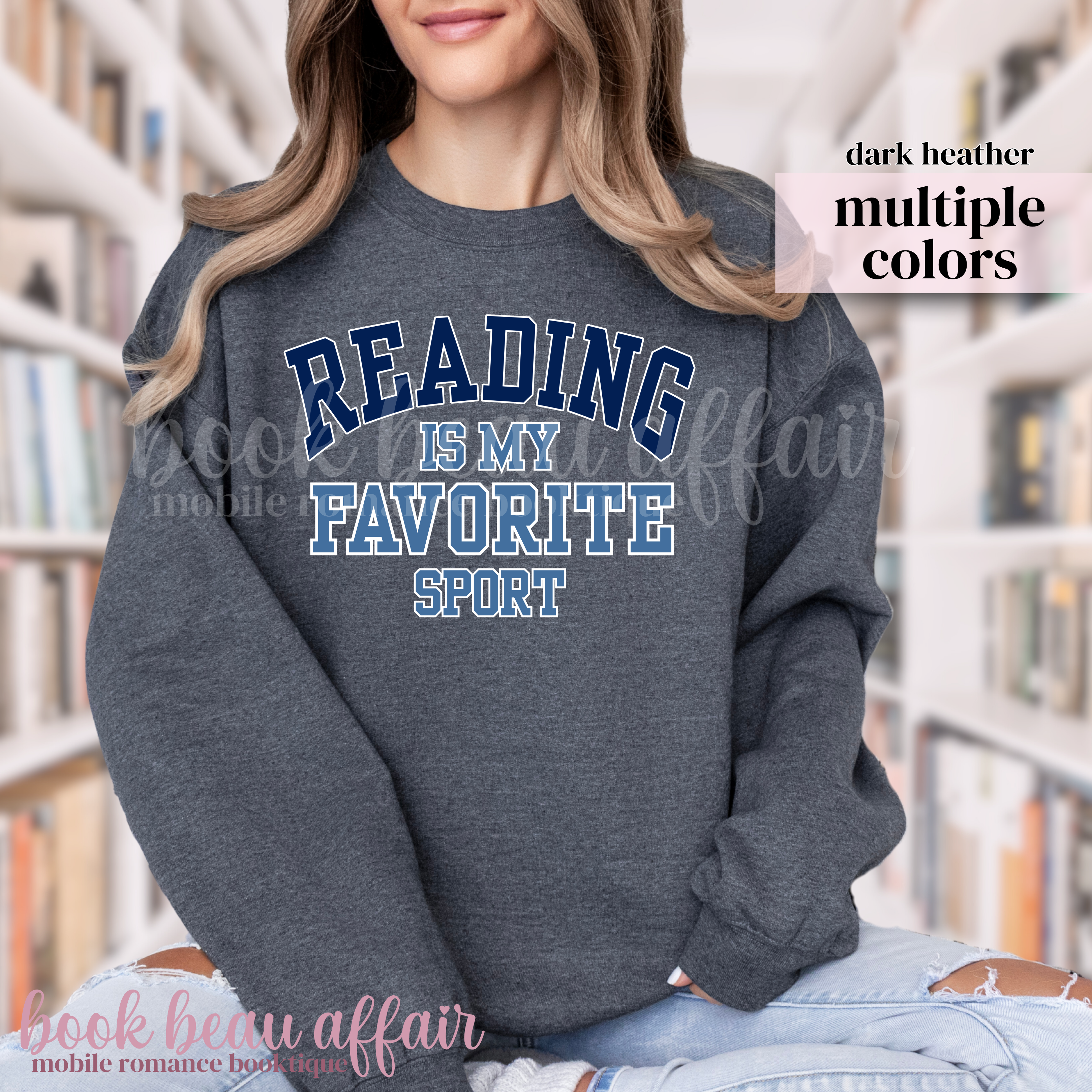 Person wearing a dark Heather sweatshirt with 'Reading is my favorite sport' text in a library setting.