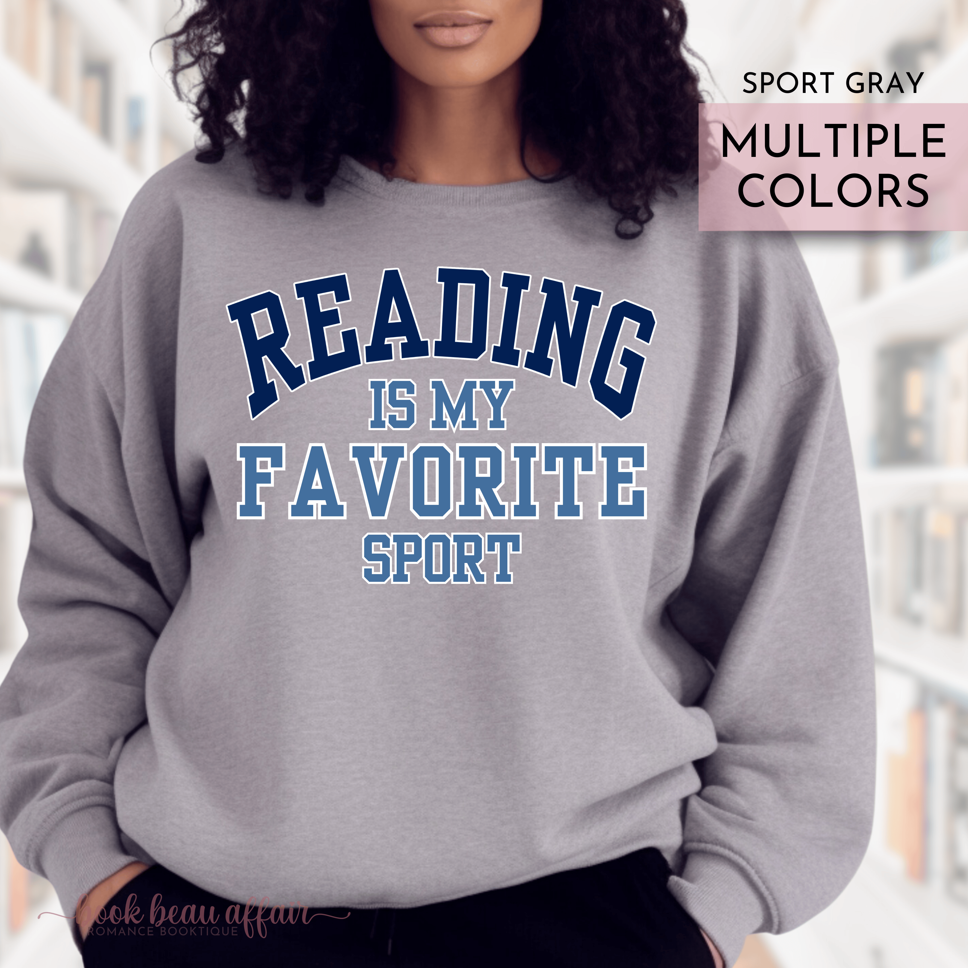 Gray sweatshirt with 'Reading is my favorite sport' text worn by a person, with a blurred background.