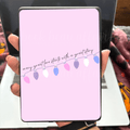 Kindle case insert with colorful lights on a pink background displaying the text every great love starts with a great story