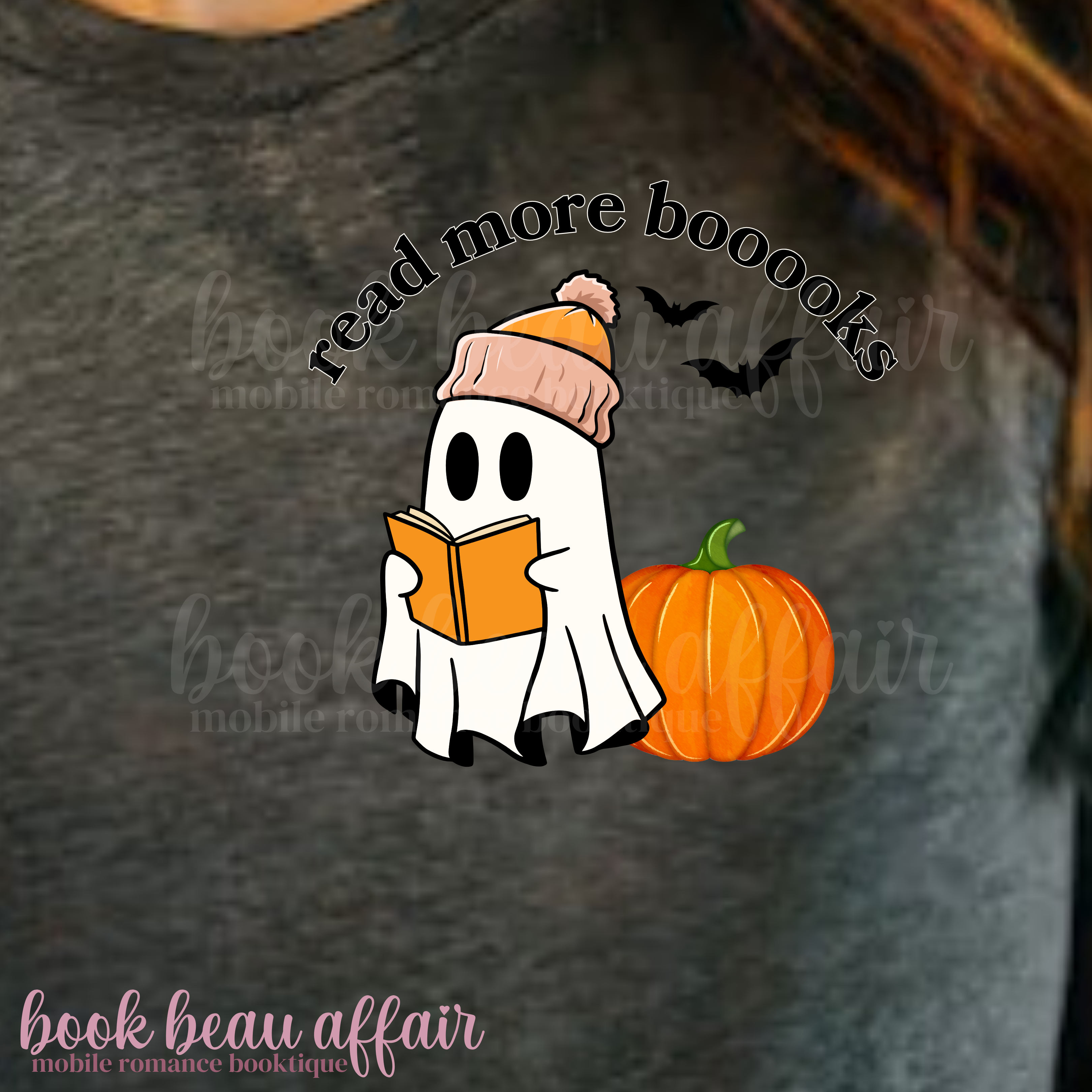 Gray t-shirt with a ghost reading a book, pumpkin, and 'read more boooks' text on a dark background.