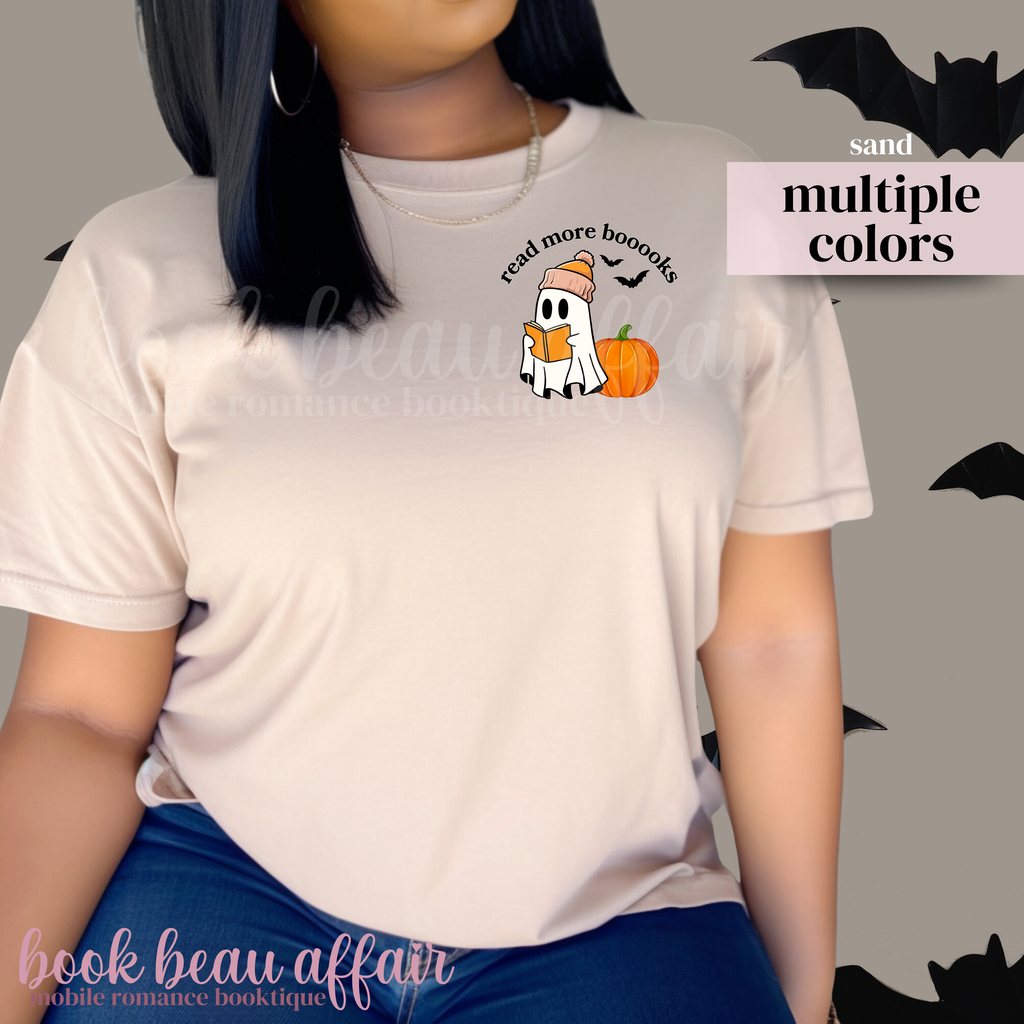 Person wearing a beige t-shirt with a ghost and pumpkin graphic, text that says 'read more booooks'