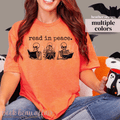 Orange t-shirt that has skeletons reading and text that says read in peace.