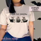 t-shirt that has skeletons reading and text that says read in peace.