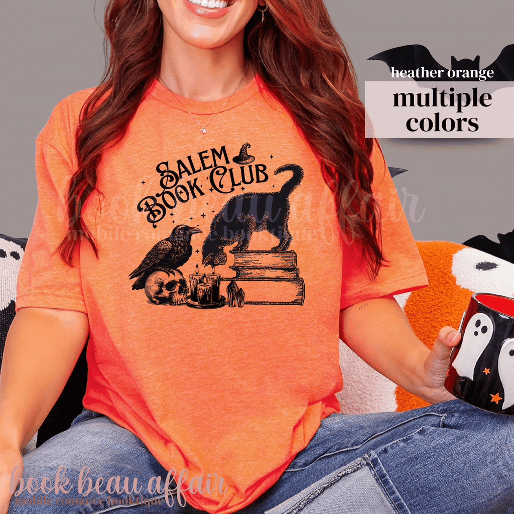 Orange t-shirt with 'Salem Book Club' design featuring a black cat, raven, and books.