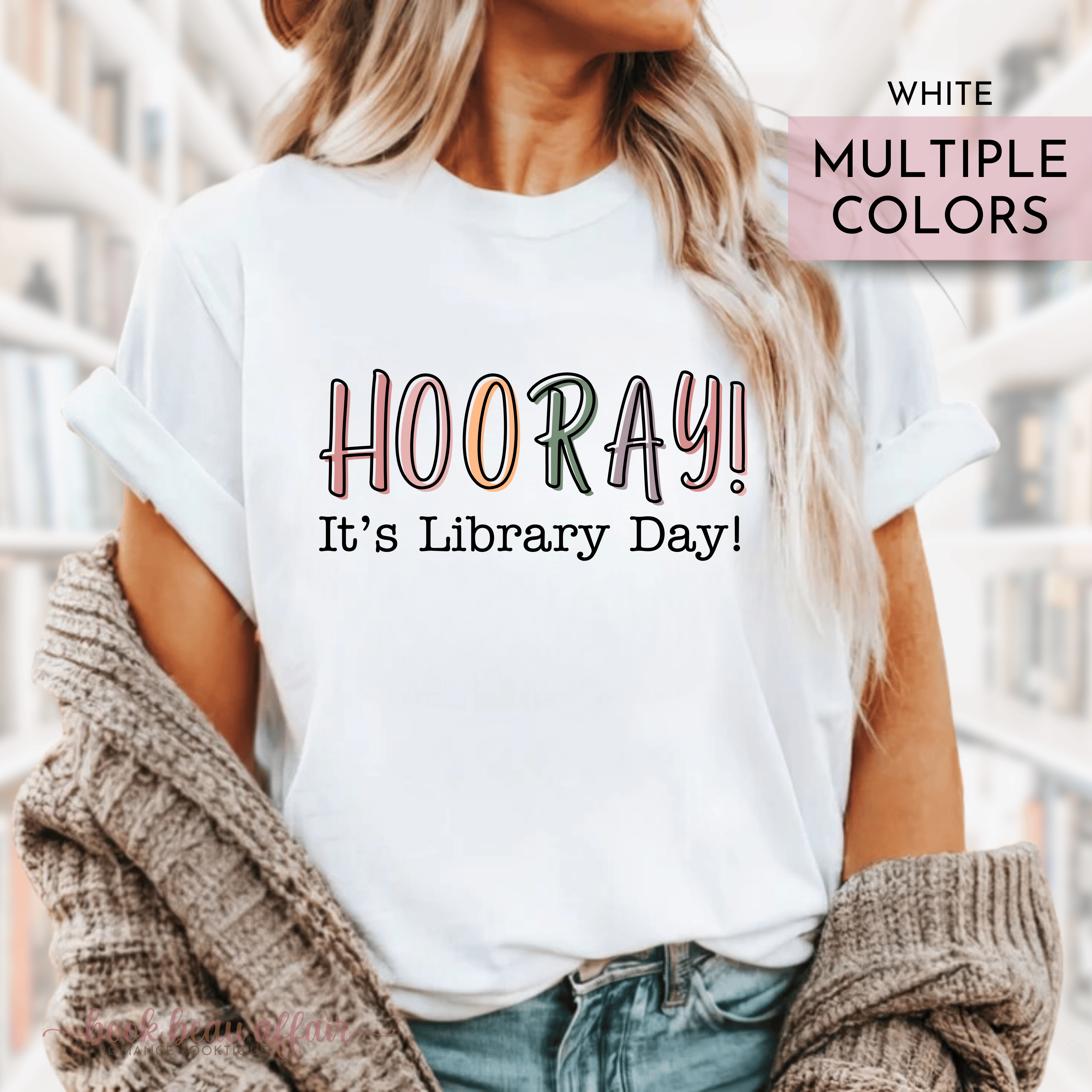 A person wearing a white t-shirt with the text 'HOORAY! It's Library Day!' printed on the front.