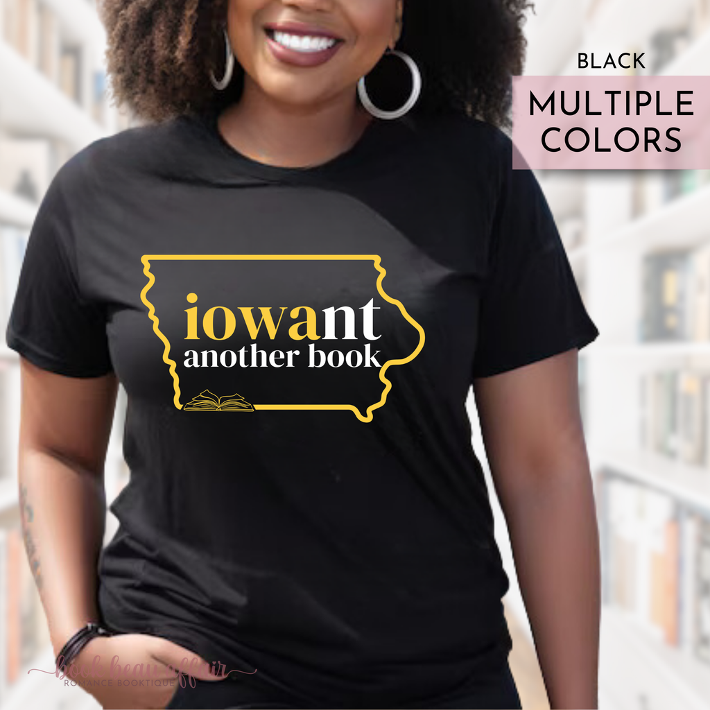 Person wearing a black t-shirt with 'iowant another book' design in Iowa Hawkeys colors, standing outdoors.